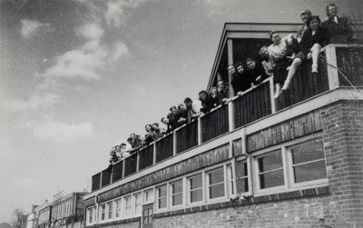 811663 Afbeelding van de toeschouwers bij een roeiwedstrijd van de roeivereniging Viking op het balkon van het ...